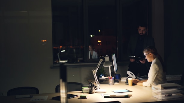 People working late in a dimly lit office.