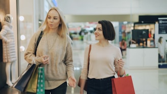 Two women shopping in a bright, modern mall.