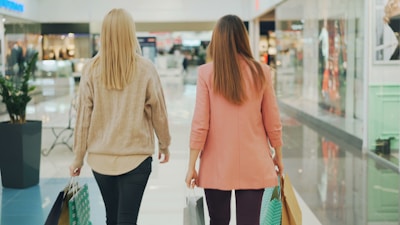 Two women walking in a brightly lit shopping mall.