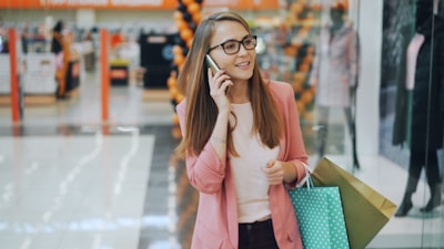 Woman talking on phone while shopping with bags