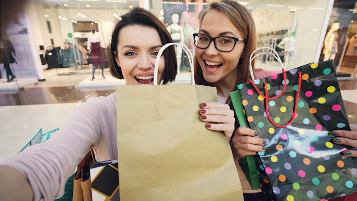 Two happy women holding shopping bags