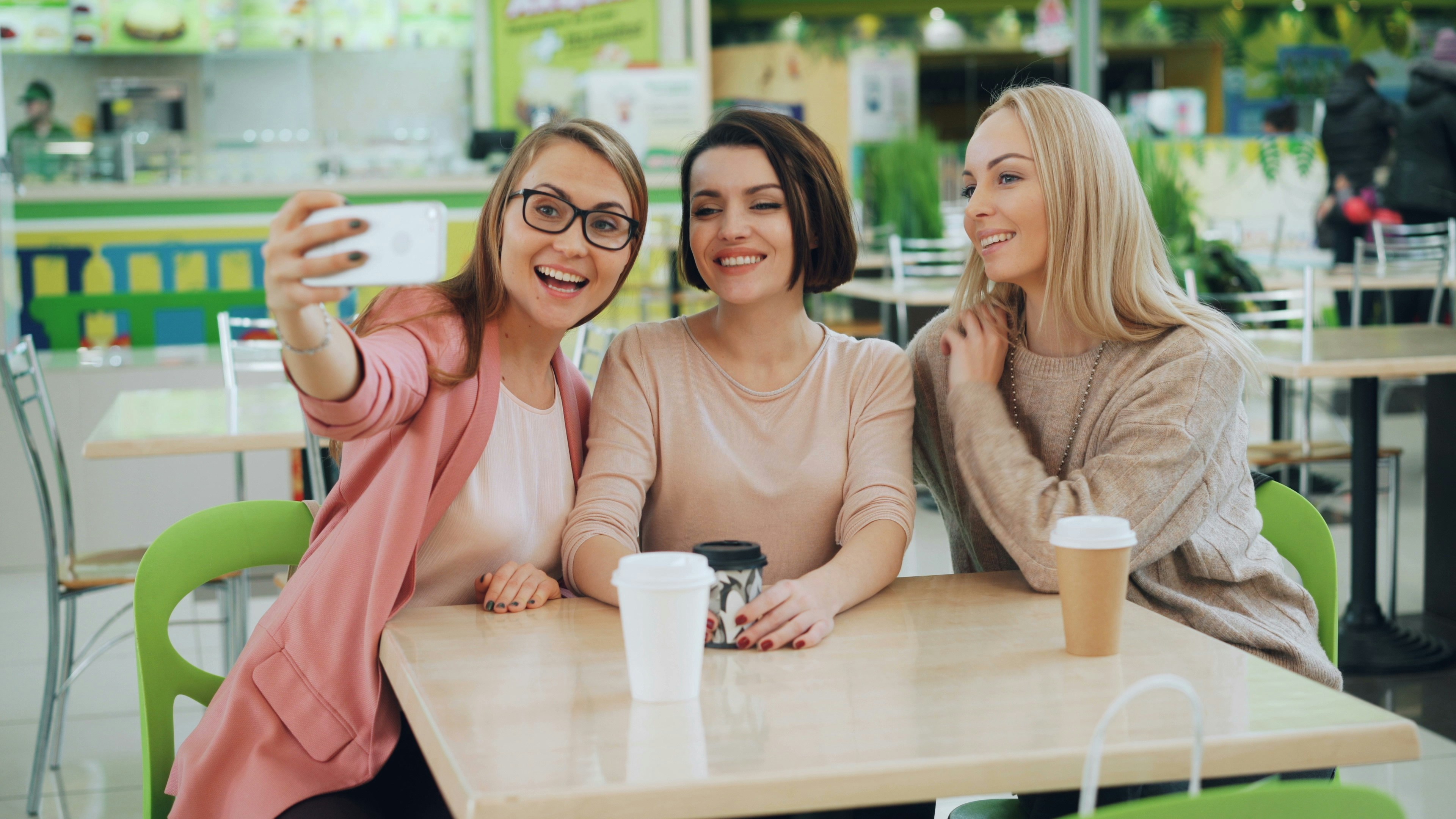 Three friends taking a selfie at a cafe