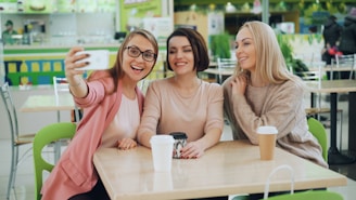 Three friends taking a selfie at a cafe
