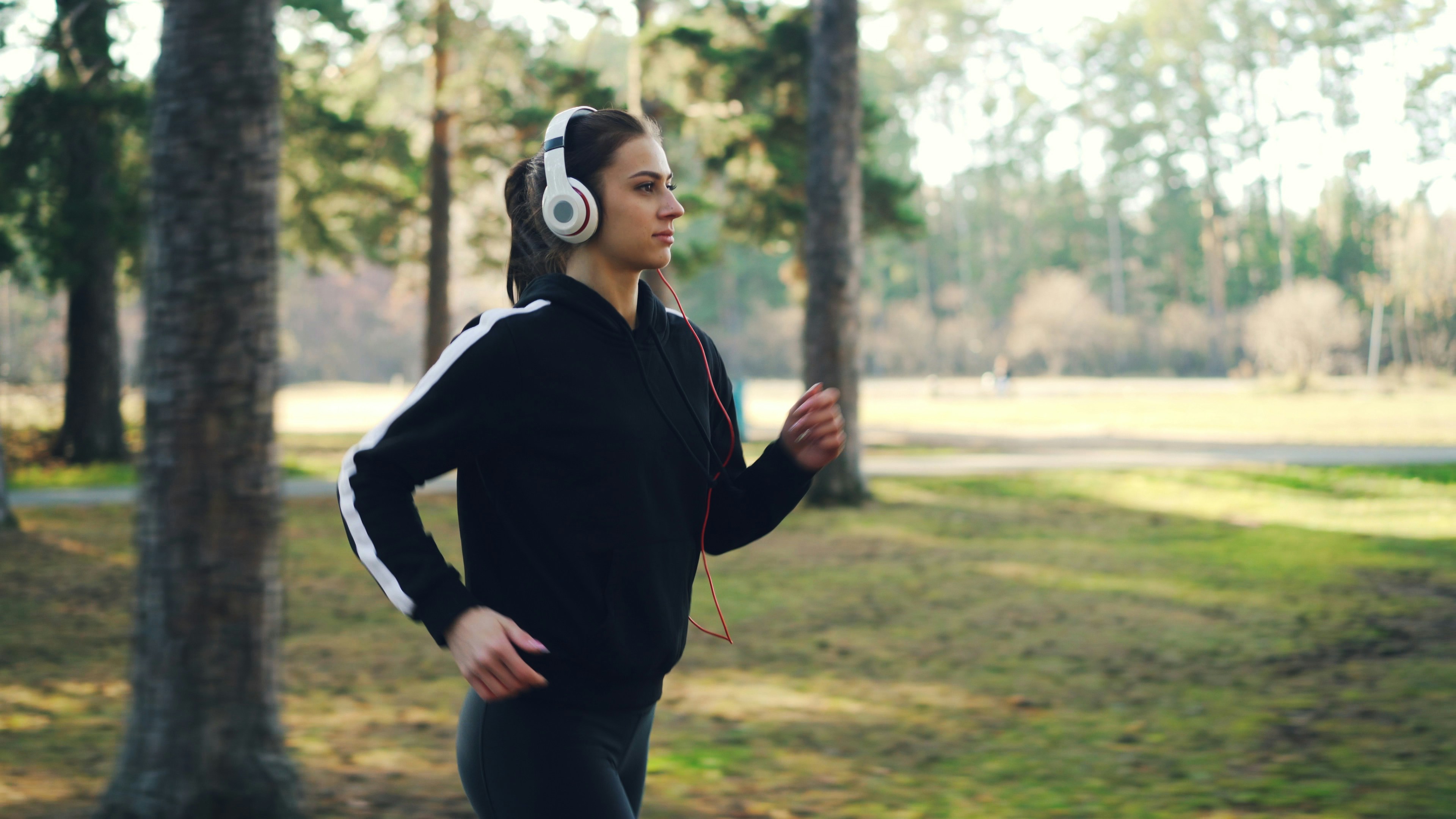 Young woman jogging in park with headphones
