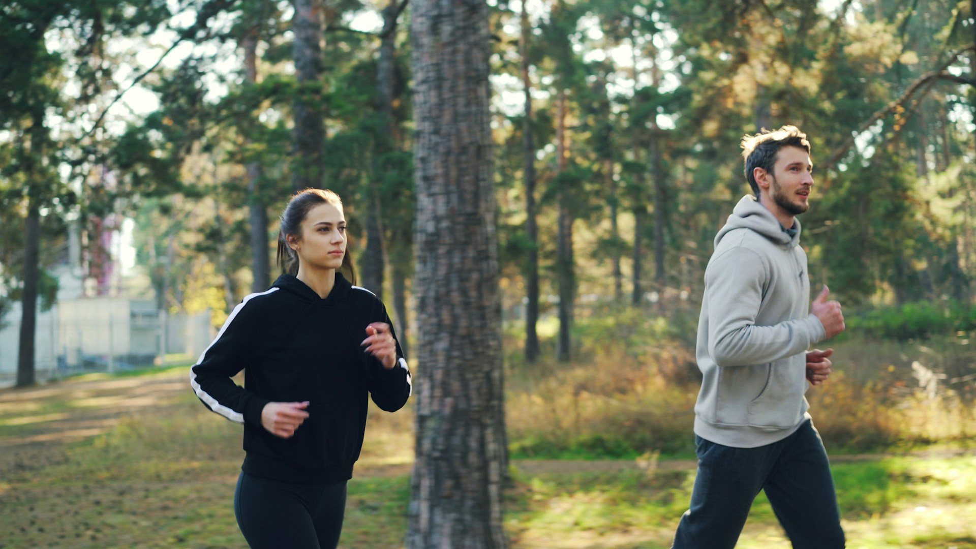 Man and woman jogging together in a park.