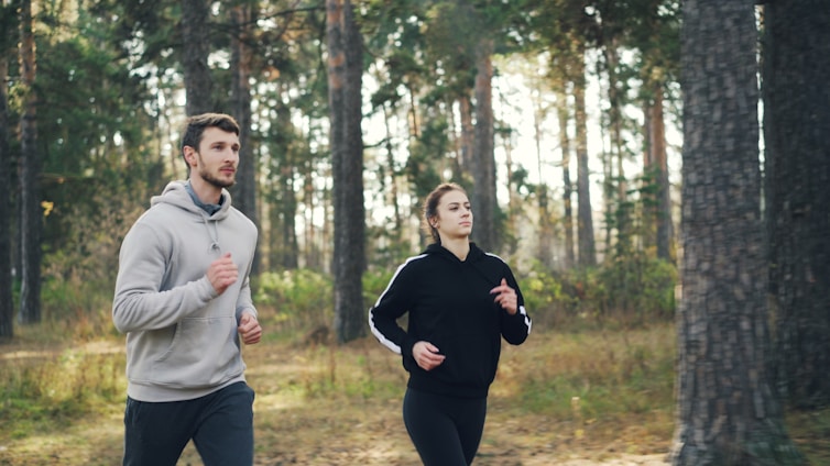Couple jogging together in a forest