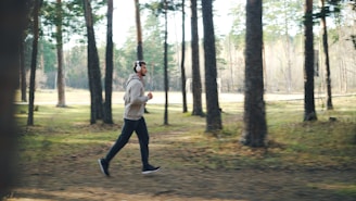 Man running with headphones in a forest