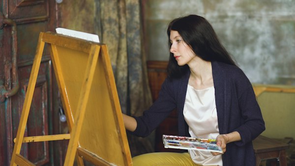 Woman painting with watercolors at an easel