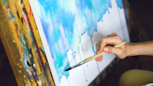 Artist painting abstract blue watercolor on canvas.