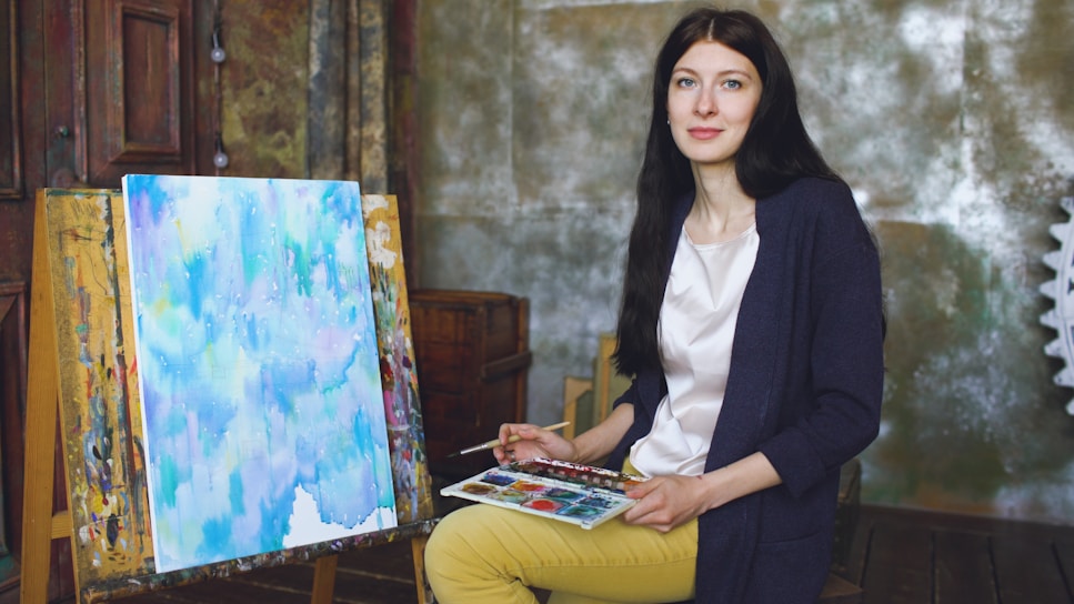 Artist painting abstract artwork on canvas