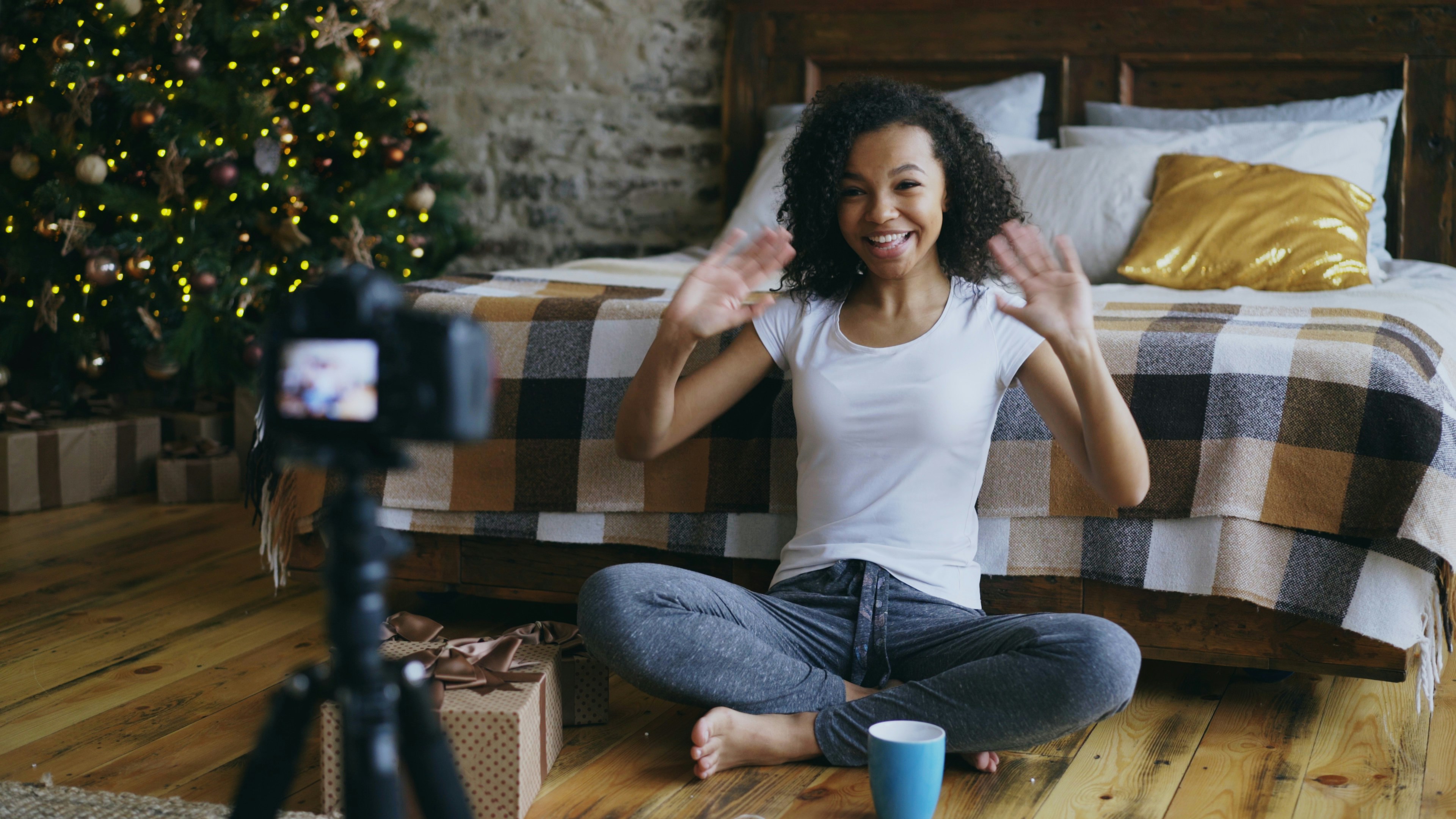 Young woman waves at camera in decorated room