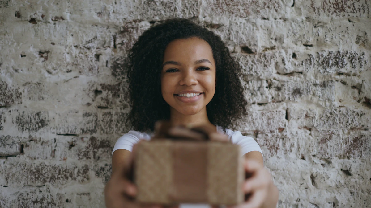 A smiling woman presenting a wrapped Dera Gifts gift box
