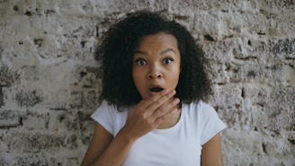 A surprised woman with hand over her mouth