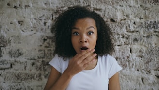 A surprised woman with hand over her mouth