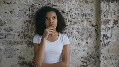 Young woman with hand on chin thinking