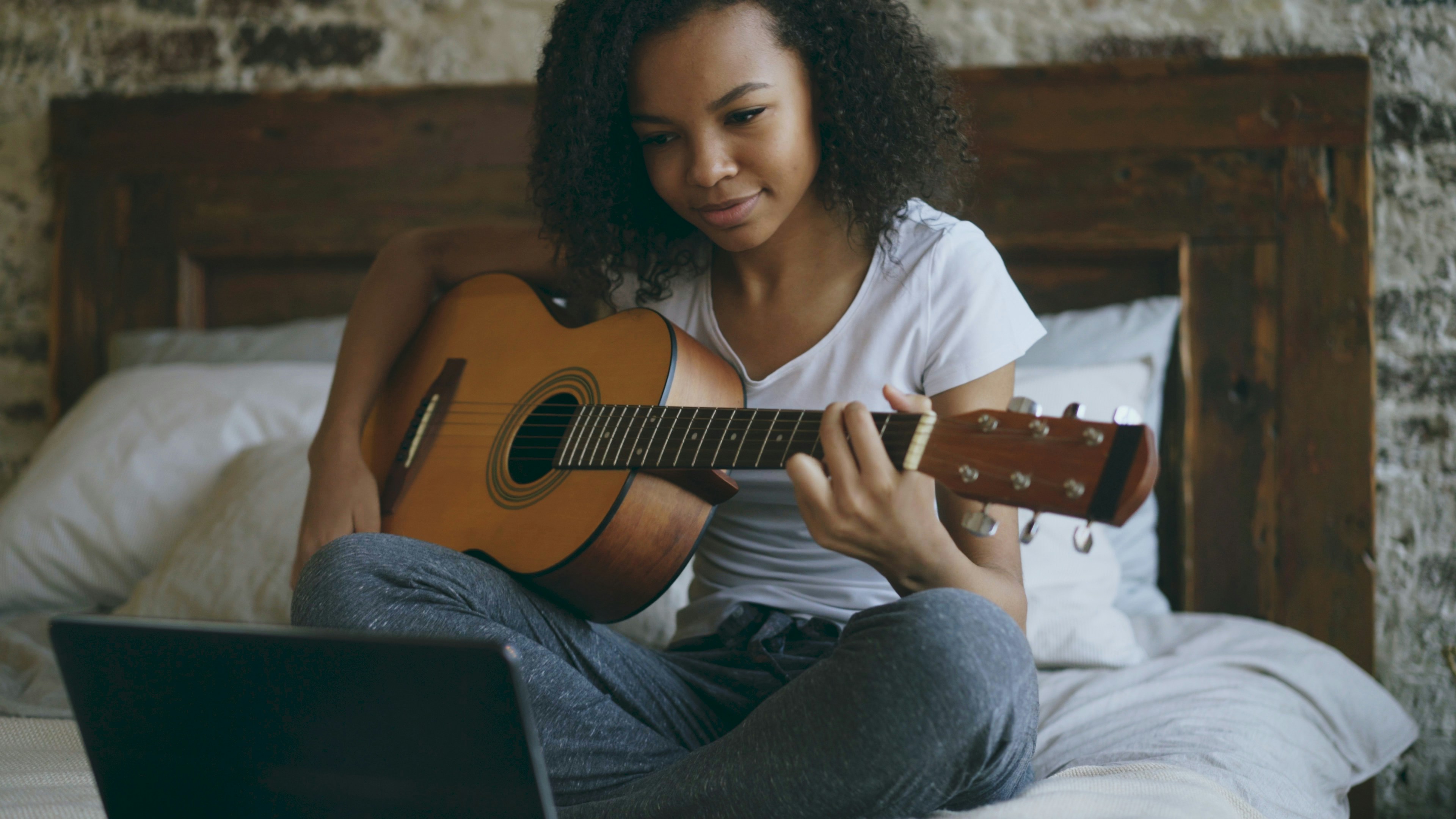 Teenager concentrating on guitar practice