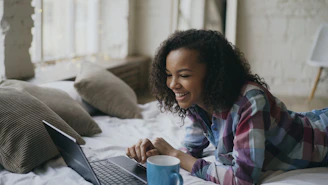 Young woman laughing while looking at laptop on laptop