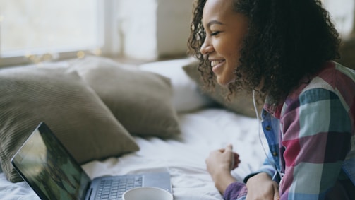 Young woman smiling while looking at laptop screen
