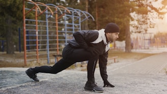 Man stretching outdoors near playground equipment.