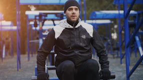 Man exercising outdoors on a fitness equipment.