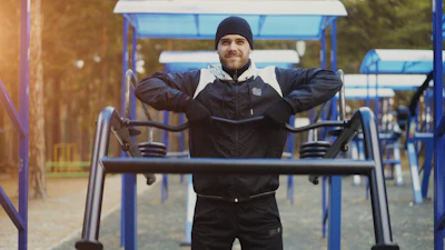 Man exercising outdoors on workout equipment