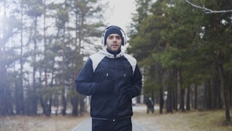 Man running in a forest with headphones on.