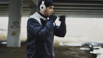 Man in headphones boxing under a bridge