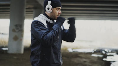 Man in headphones boxing under a bridge