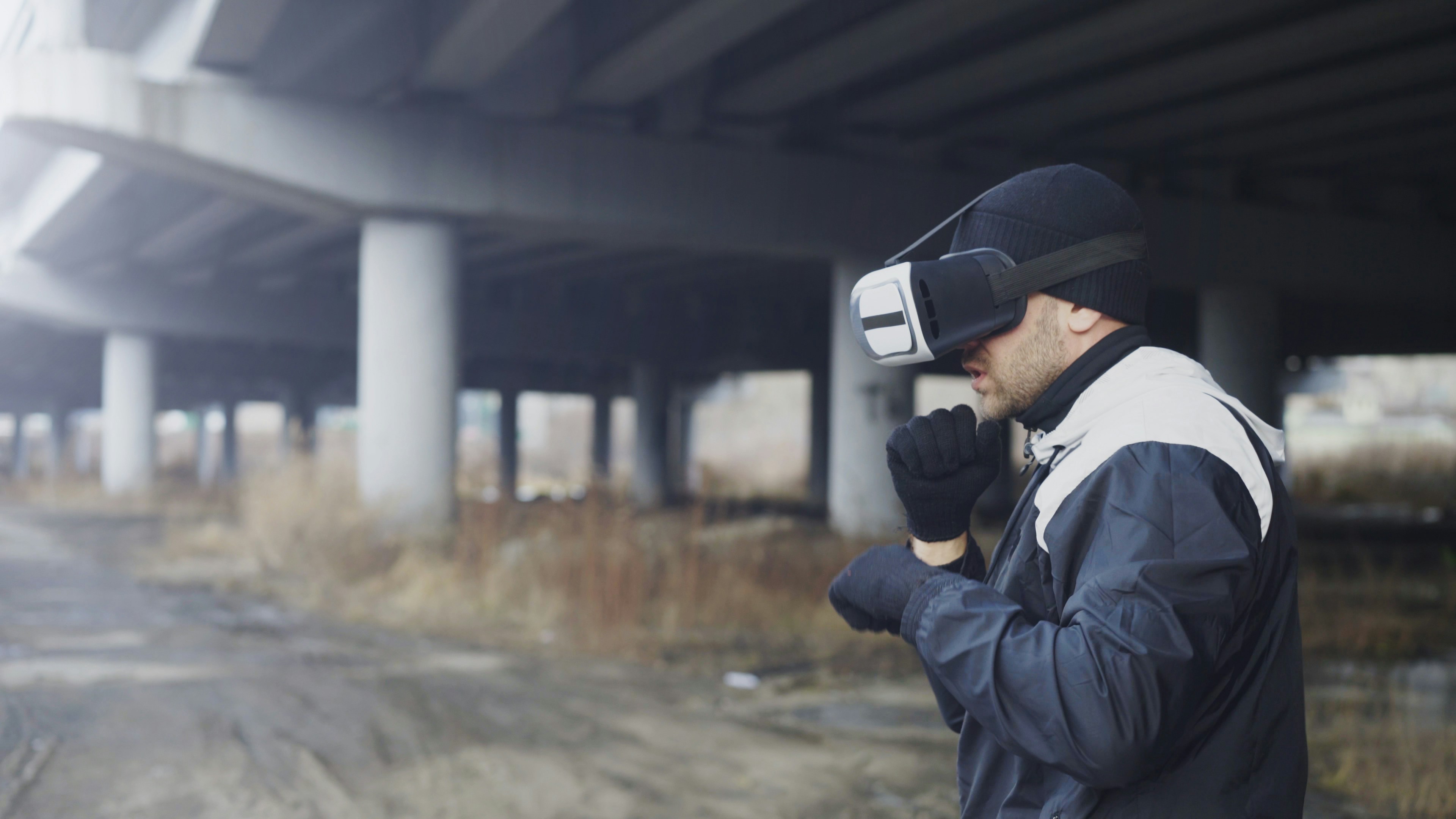 Martial boxing man in VR 360 headset training punches in virtual reality fight at urban location outdoors in winter season