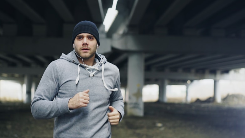 Man jogging under a concrete overpass