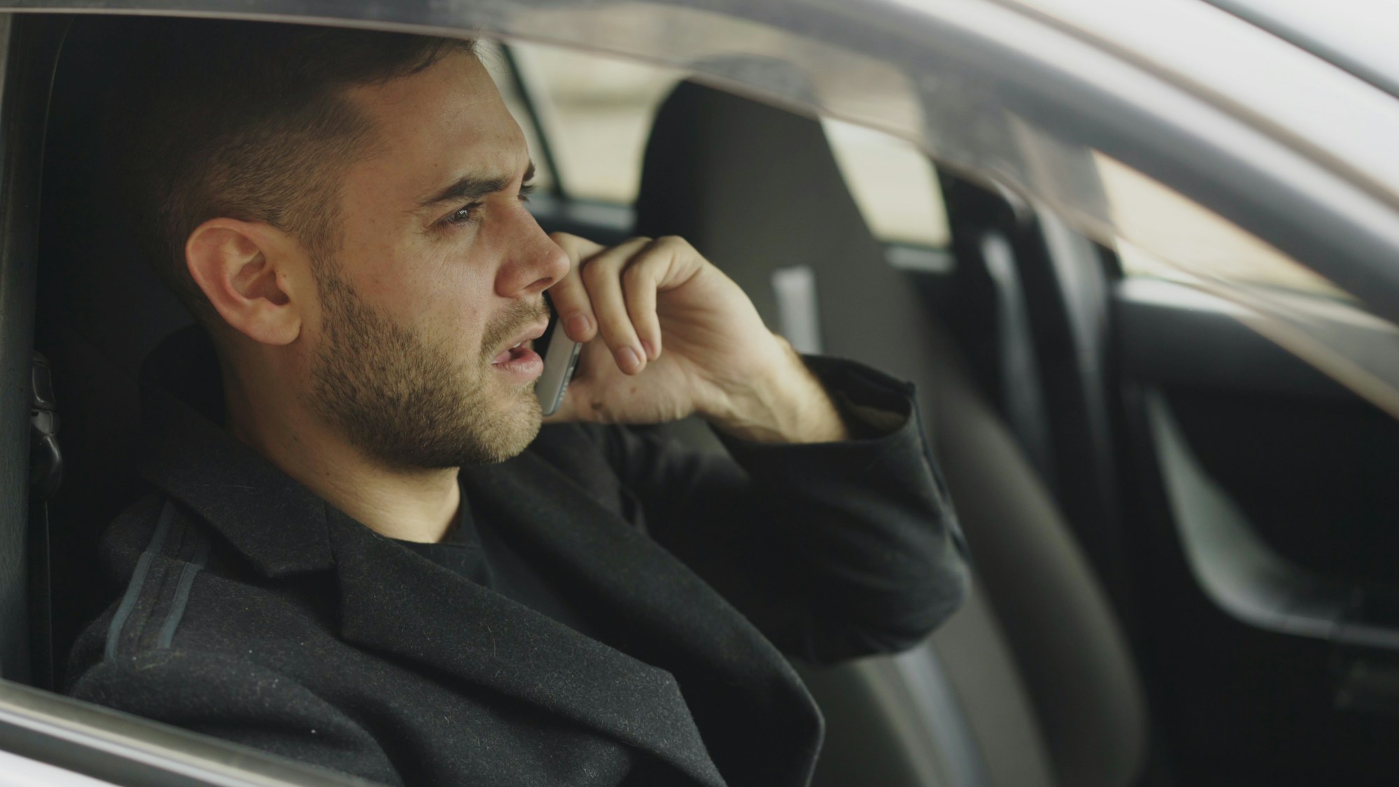 Stressed man on the phone while sitting inside his car