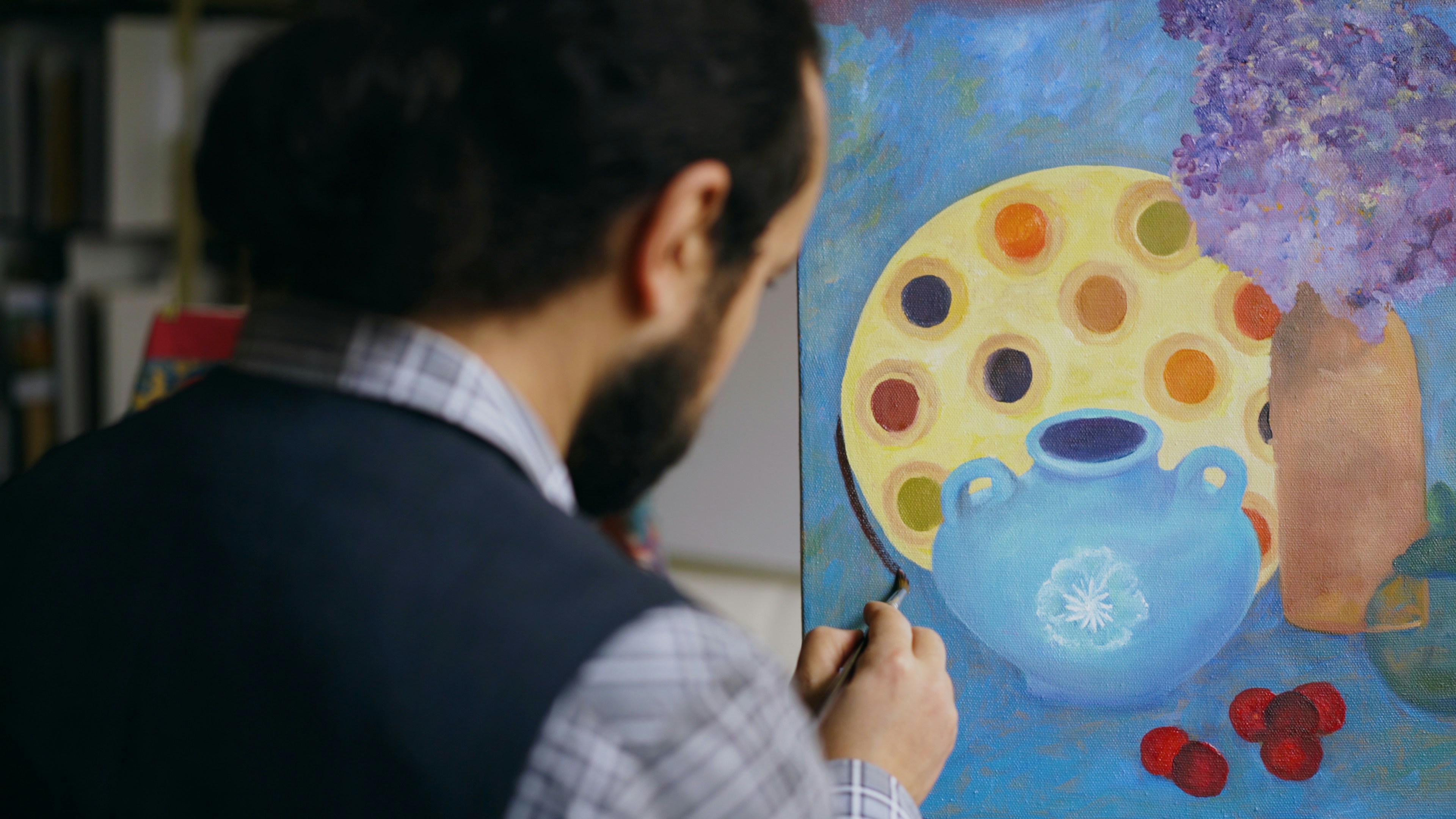 Artist painting a still life with a blue vase.