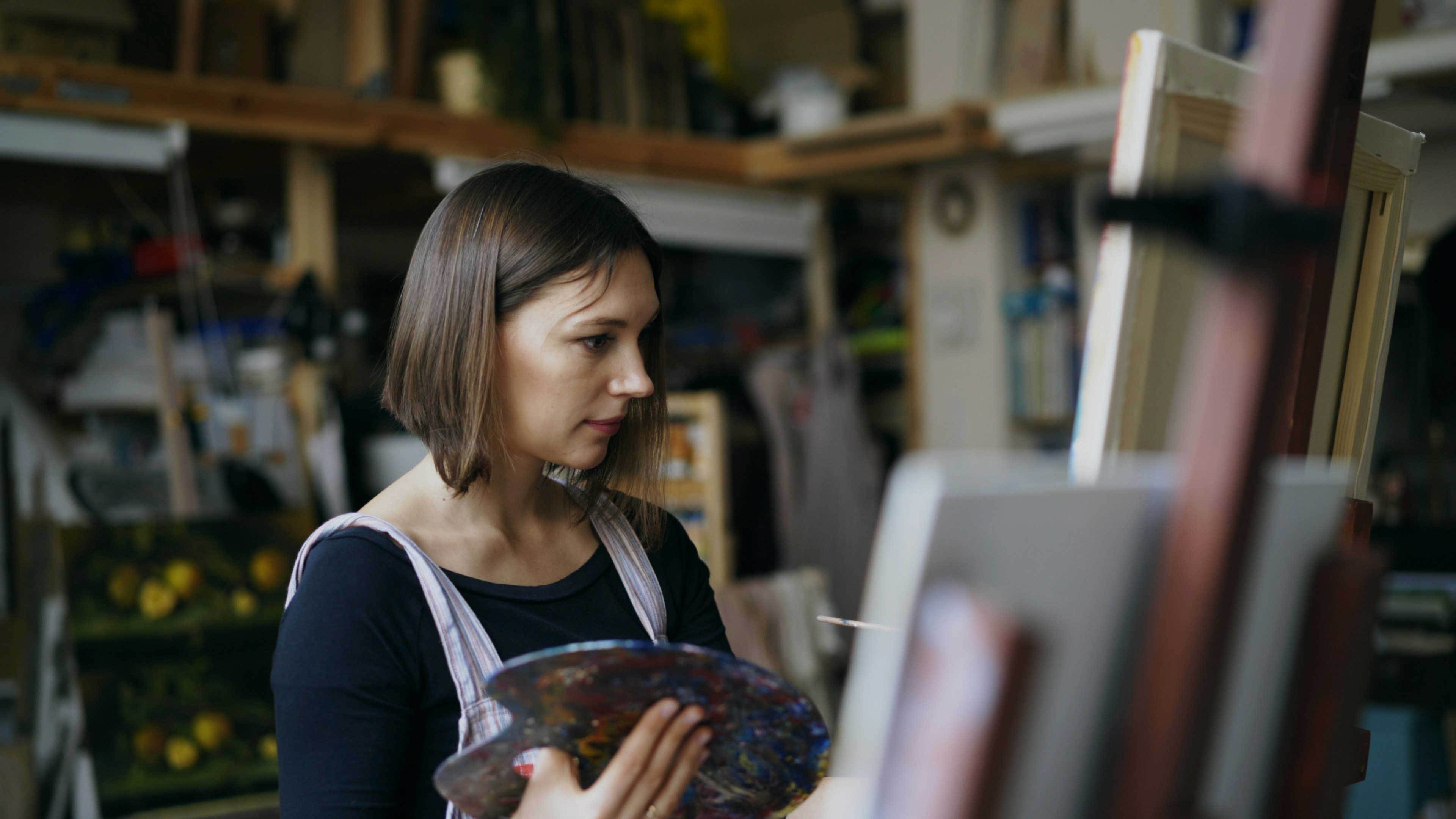 Artist painting on an easel in a studio