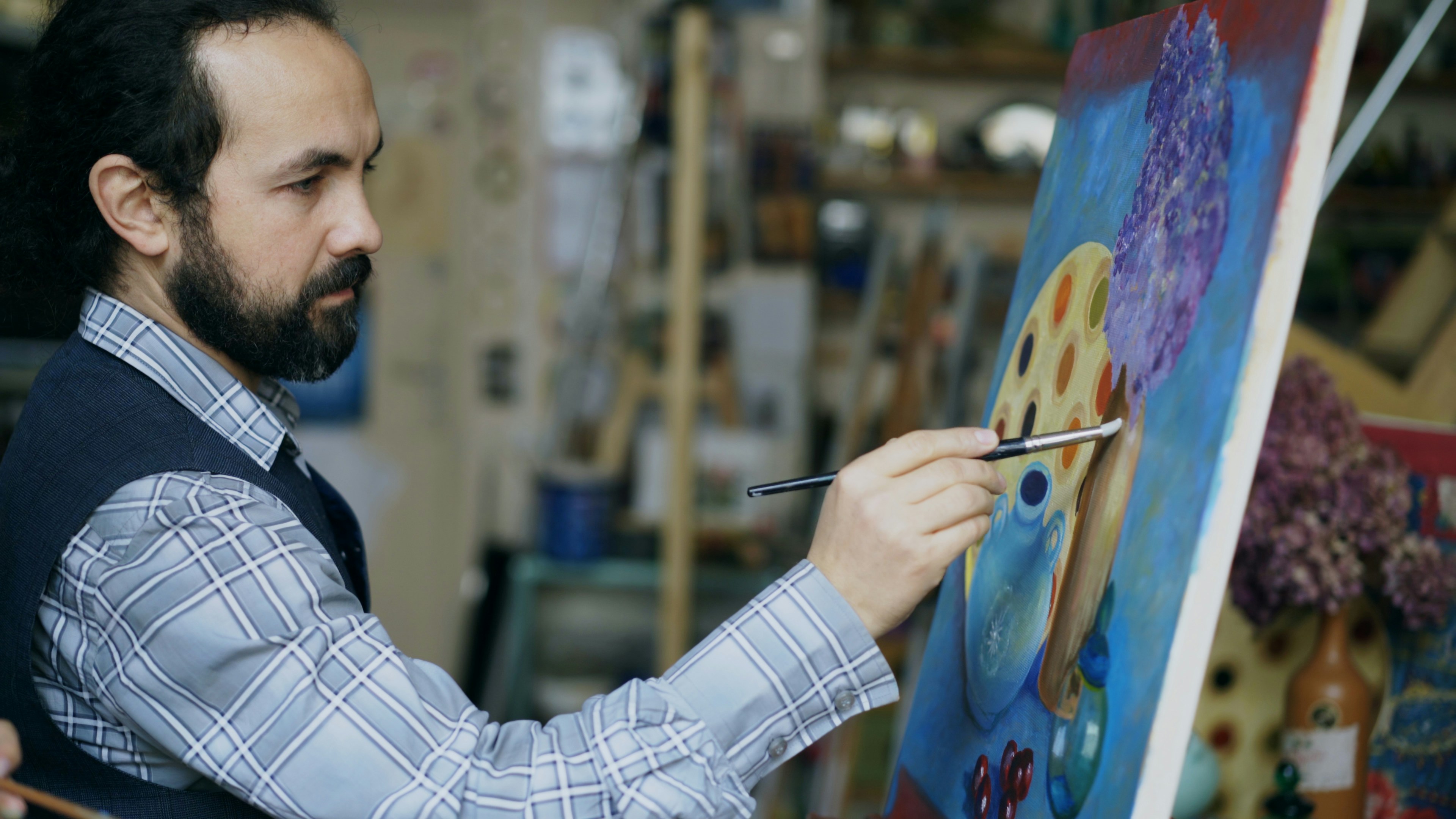 Artist painting a colorful abstract artwork on canvas.