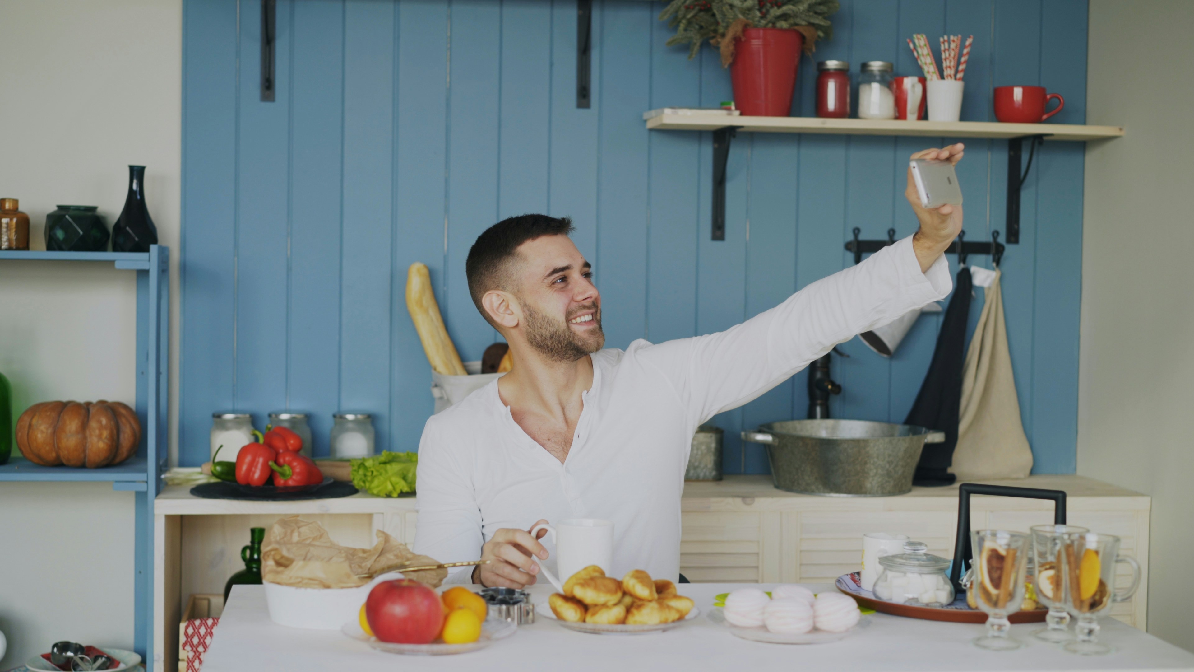 Man taking a selfie at a kitchen table