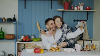 Couple taking a selfie in a kitchen during breakfast