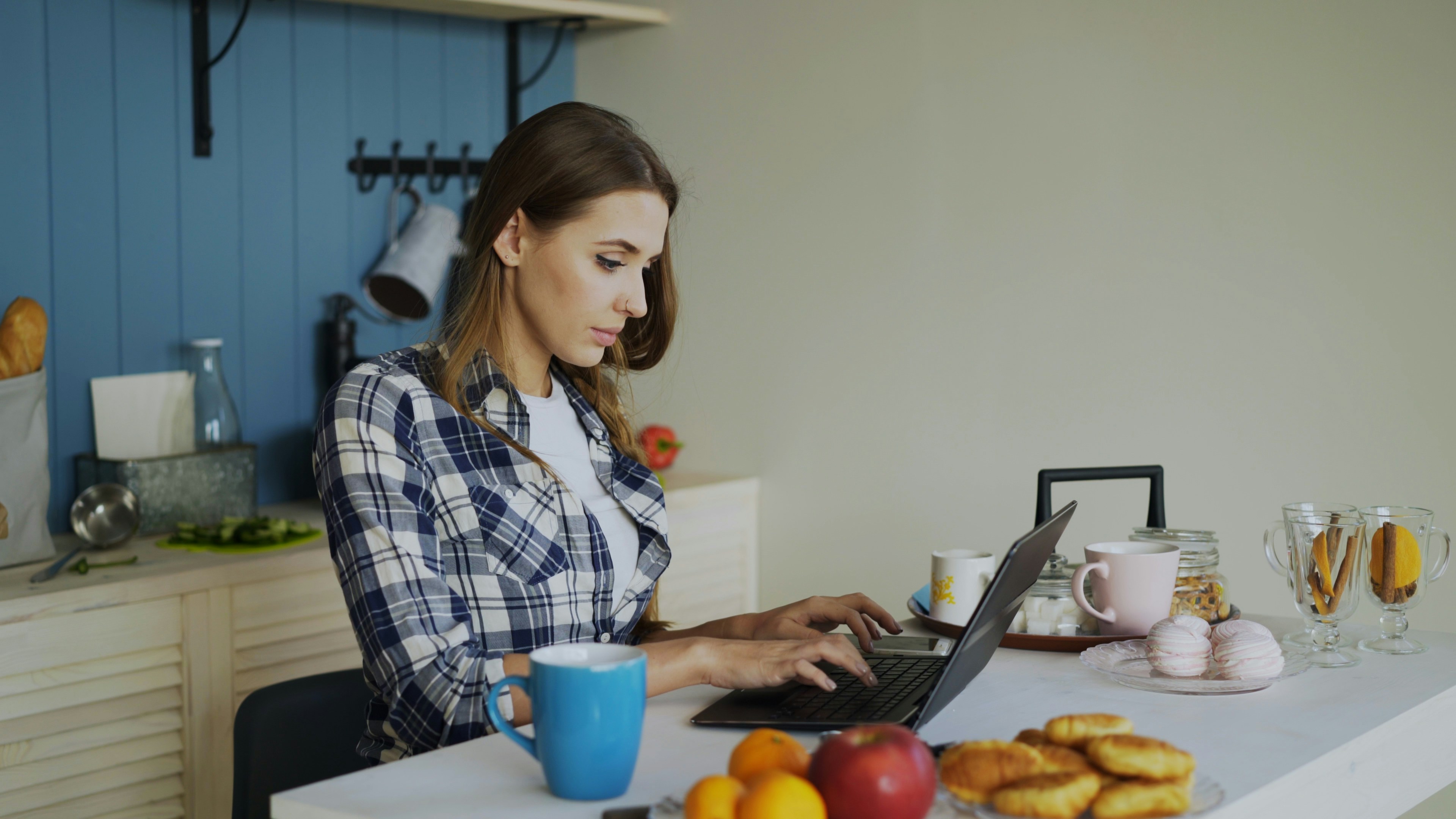 A person comfortably sitting on a sofa using the EasyHome app on a smartphone to manage their daily household tasks and meal plan.