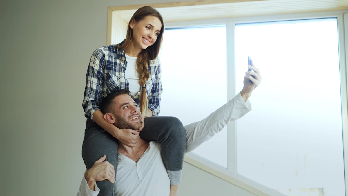 A happy couple taking a selfie by a window