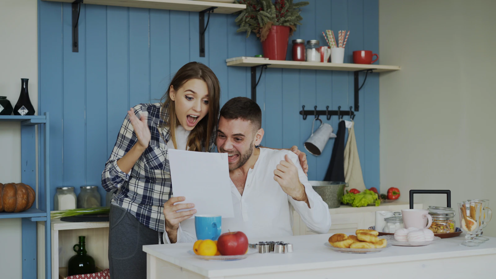A couple reading a printed report together in their kitchen
