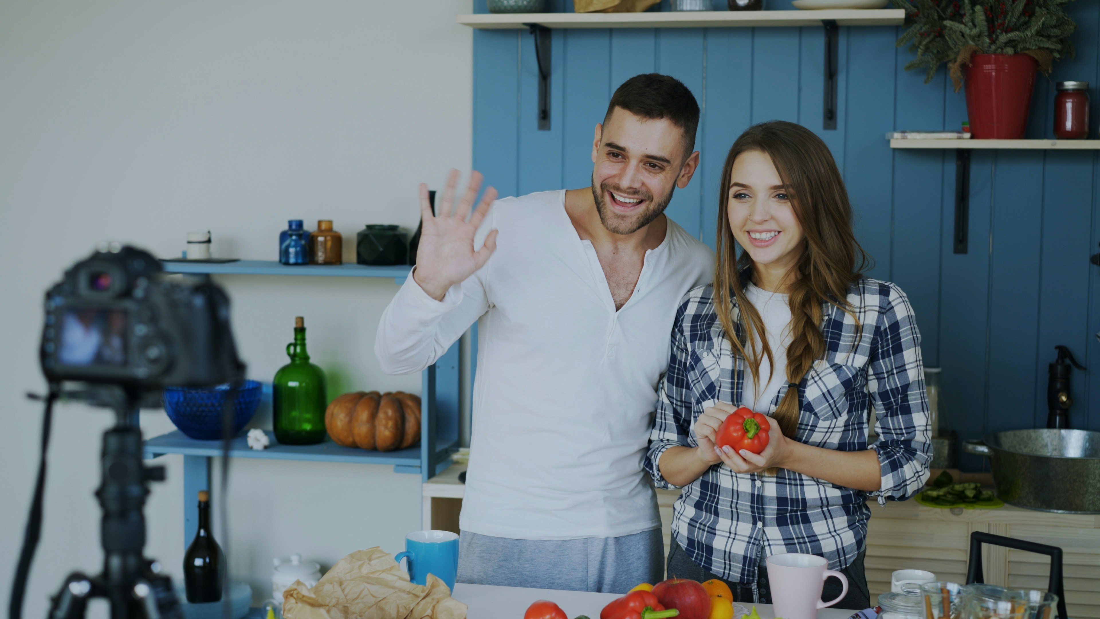 Young attractive couple recording video food blog about cooking