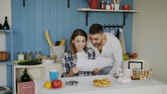 Couple looking at papers in a bright kitchen.