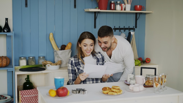 Couple looking at papers in a bright kitchen.