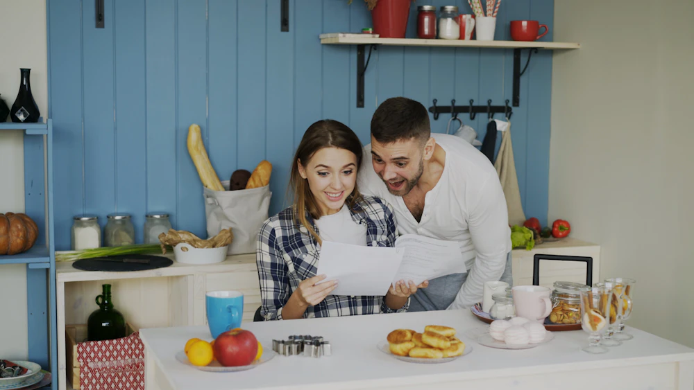 A couple looking at papers in a bright kitchen