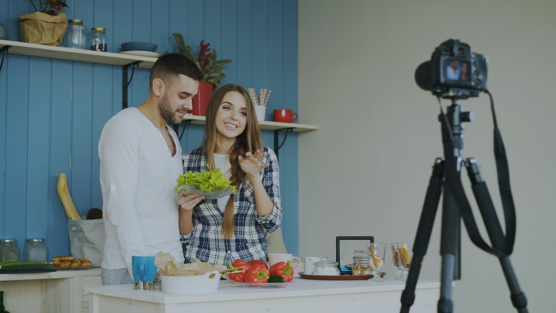 Couple filming cooking show in kitchen