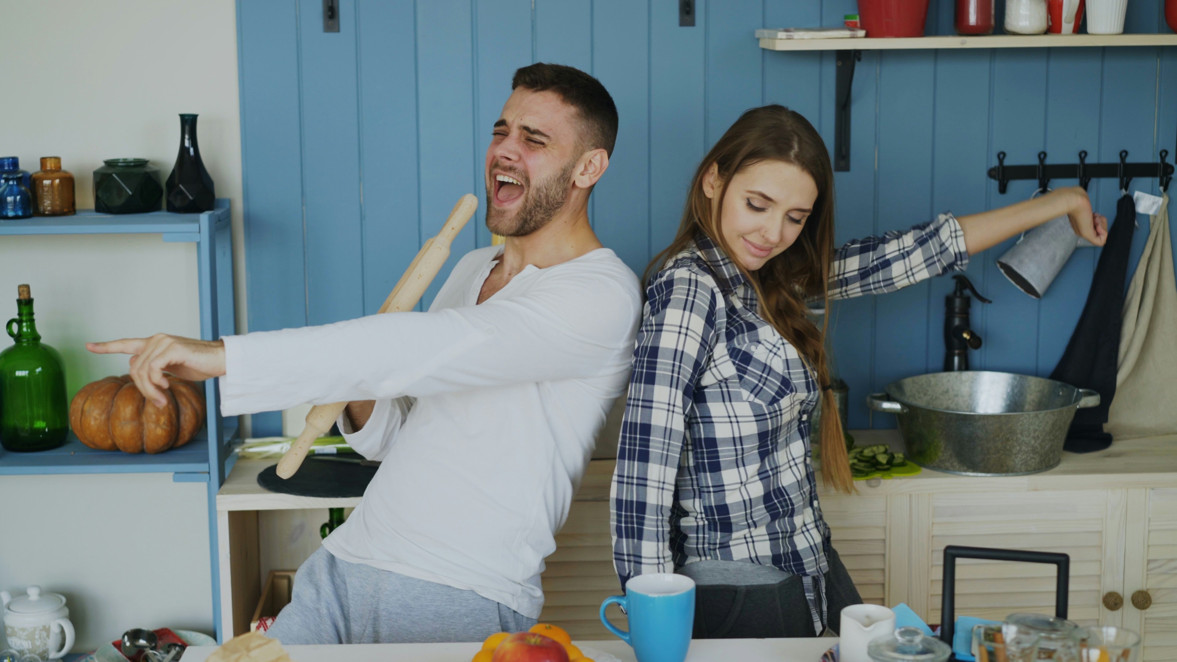 Couple dancing and singing in kitchen