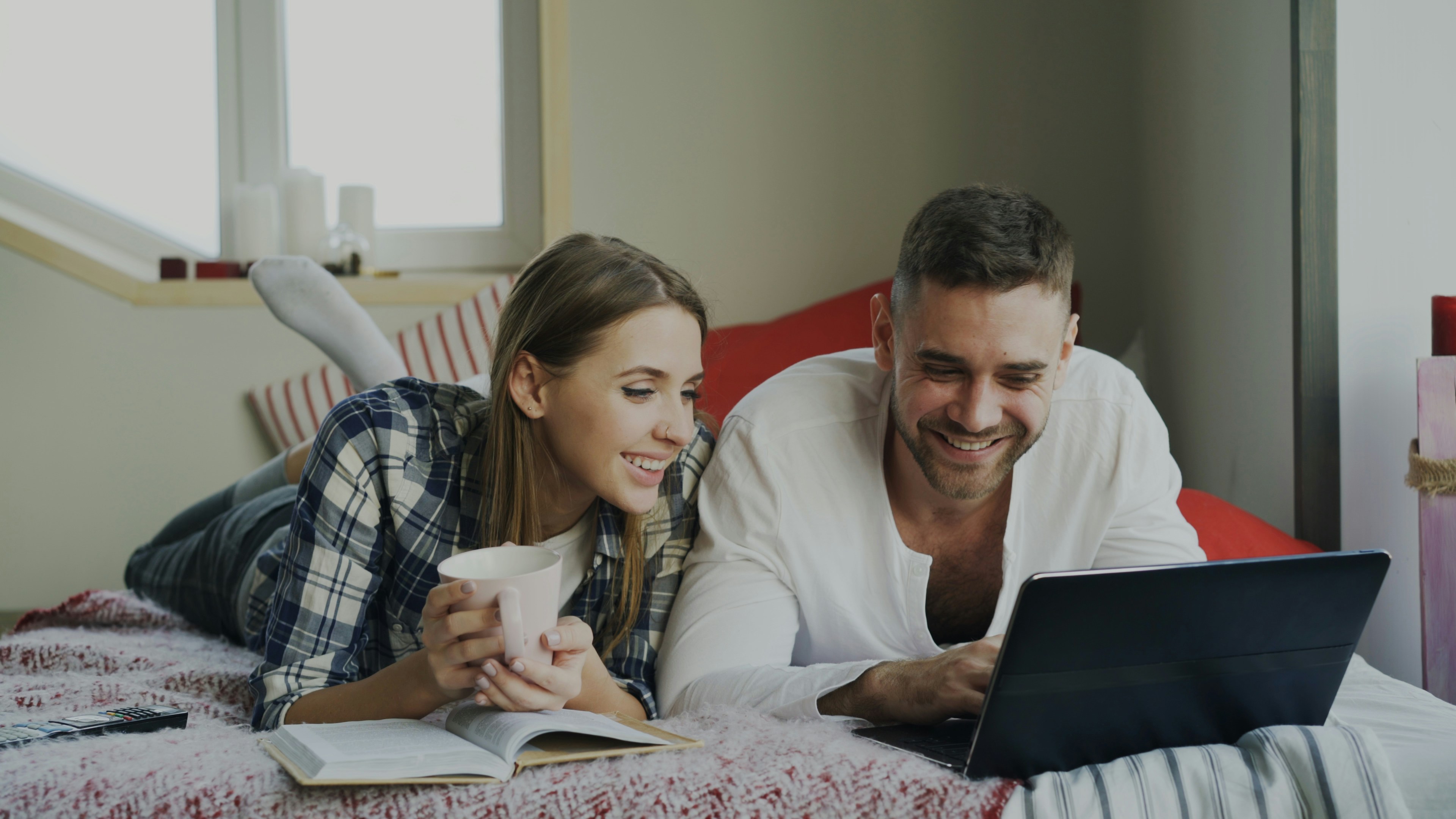 Couple looking together at a shared calendar on a tablet mounted on a kitchen wall
