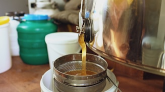 Honey is filtered into a container from a machine.