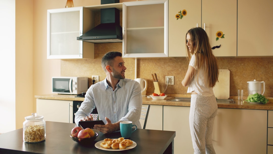 adult child comforting parent during difficult conversation at kitchen table
