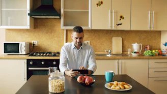 Man using tablet in modern kitchen with breakfast items.