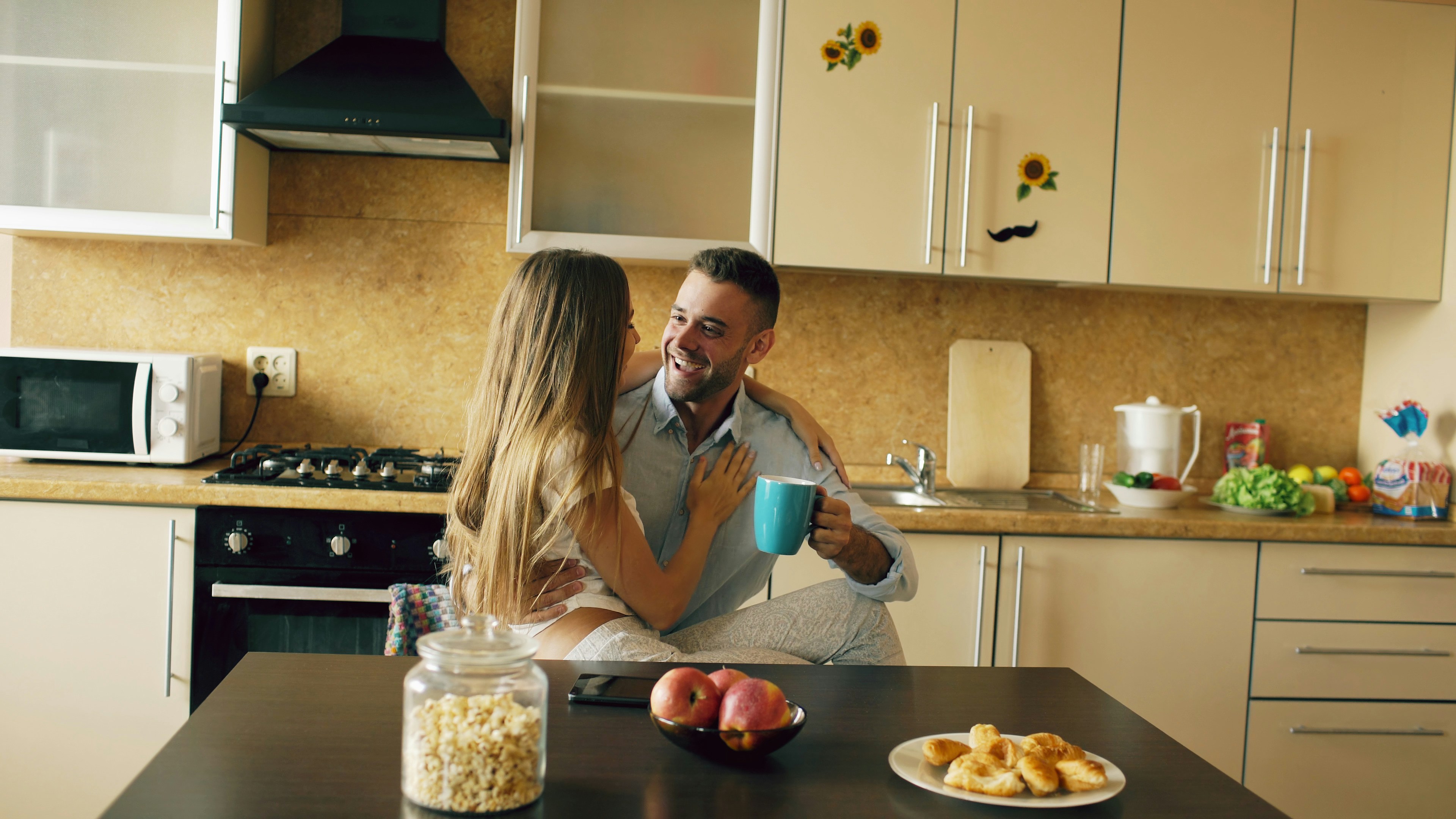 Young couple embracing in kitchen